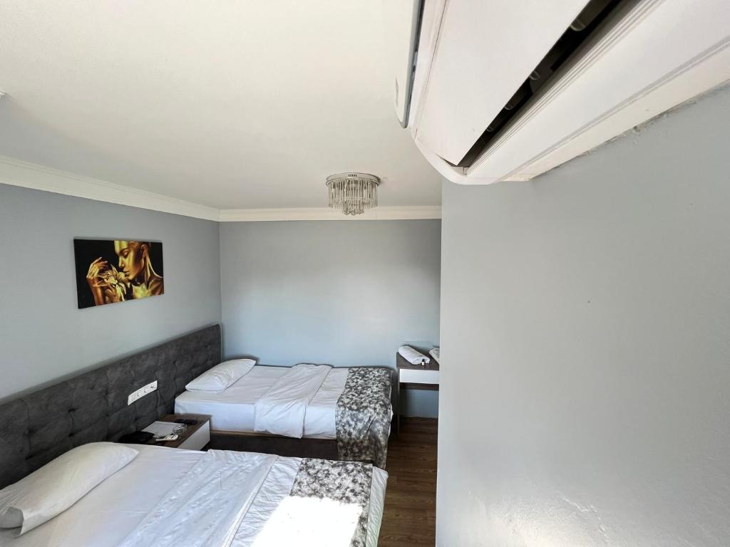 a bedroom with two beds and a wall at DUVAHi OTEL KONAKLAMA in Adana