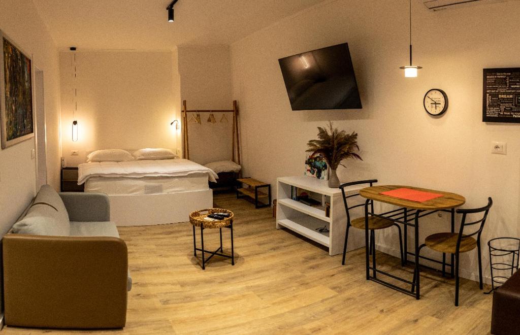 ein Wohnzimmer mit einem Bett, einem Tisch und Stühlen in der Unterkunft Blloku Studio Apartament in Tirana