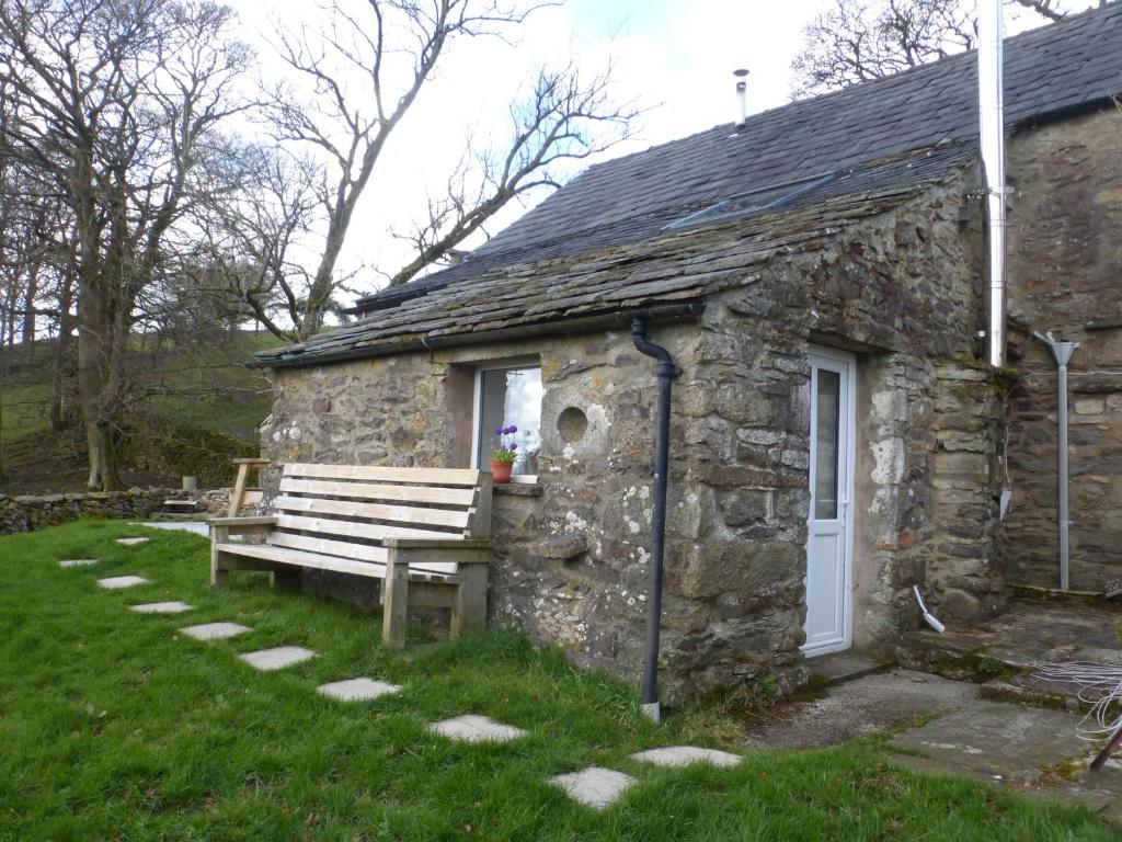 a stone building with a bench in front of it at Sally End in Ravenstonedale