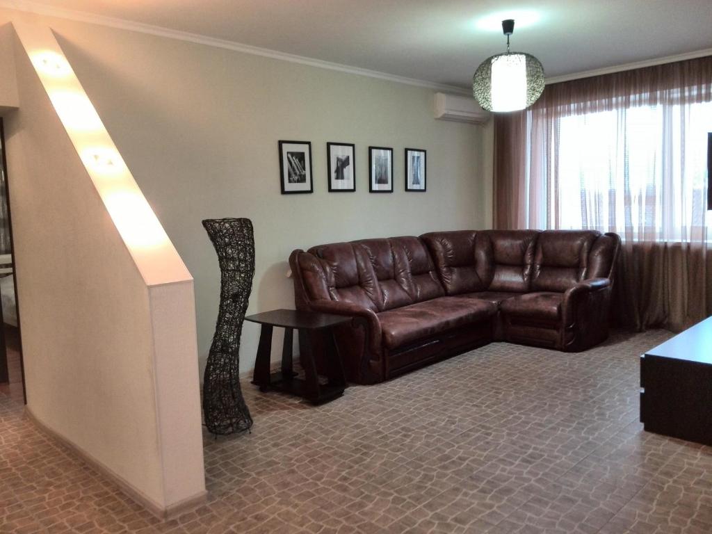 a living room with a leather couch and a table at Apartments NEW in Mykolaiv