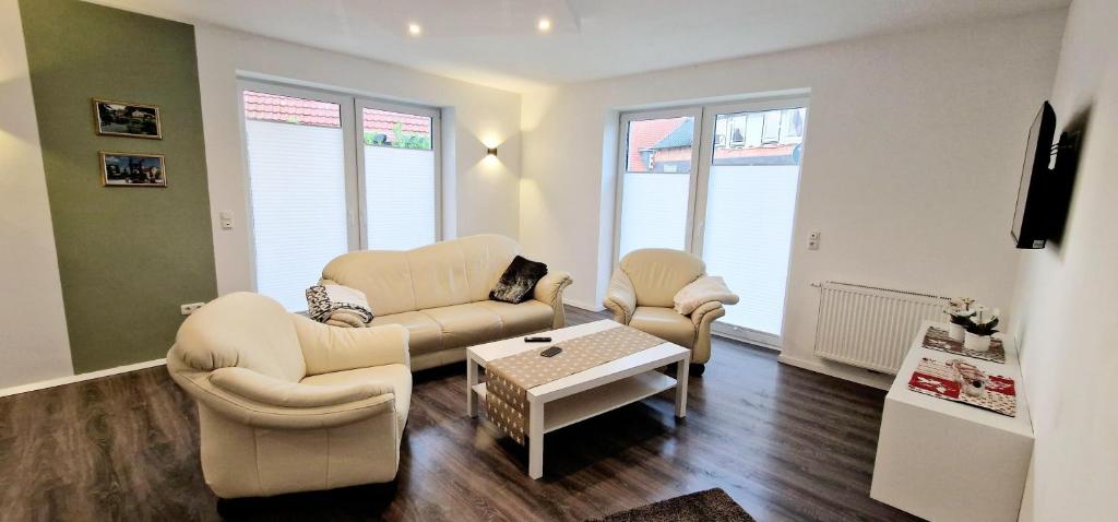 a living room with a couch and chairs and a table at Ferienhaus Strandallee 10 in Burhave