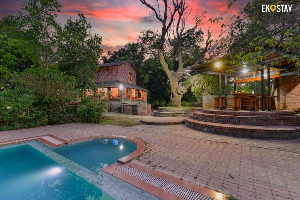 a backyard with a swimming pool and a house at EKOSTAY- Caribbean Villa in Panvel