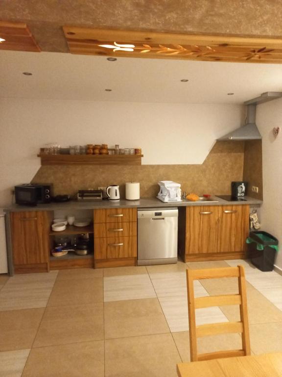 a kitchen with wooden cabinets and a counter top at Tu i Teraz - pokoje in Bukowina Tatrzańska