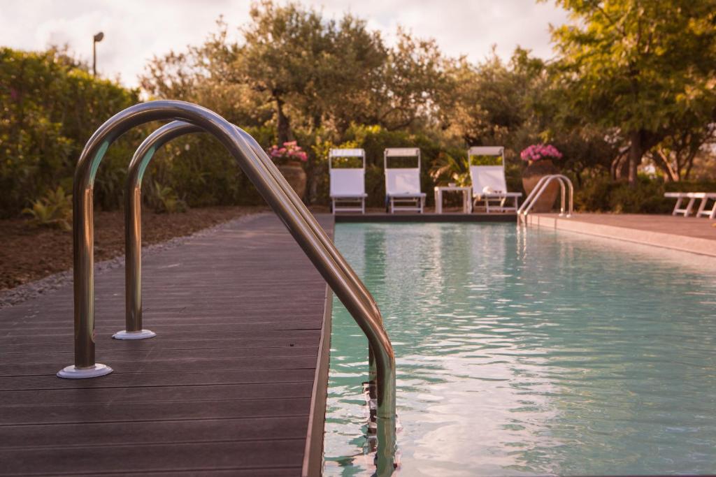 une piscine avec une promenade en bois et un pare-soleil dans l'établissement Villa Mazzaforno a Cefalu' by Wonderful Italy, à Cefalù