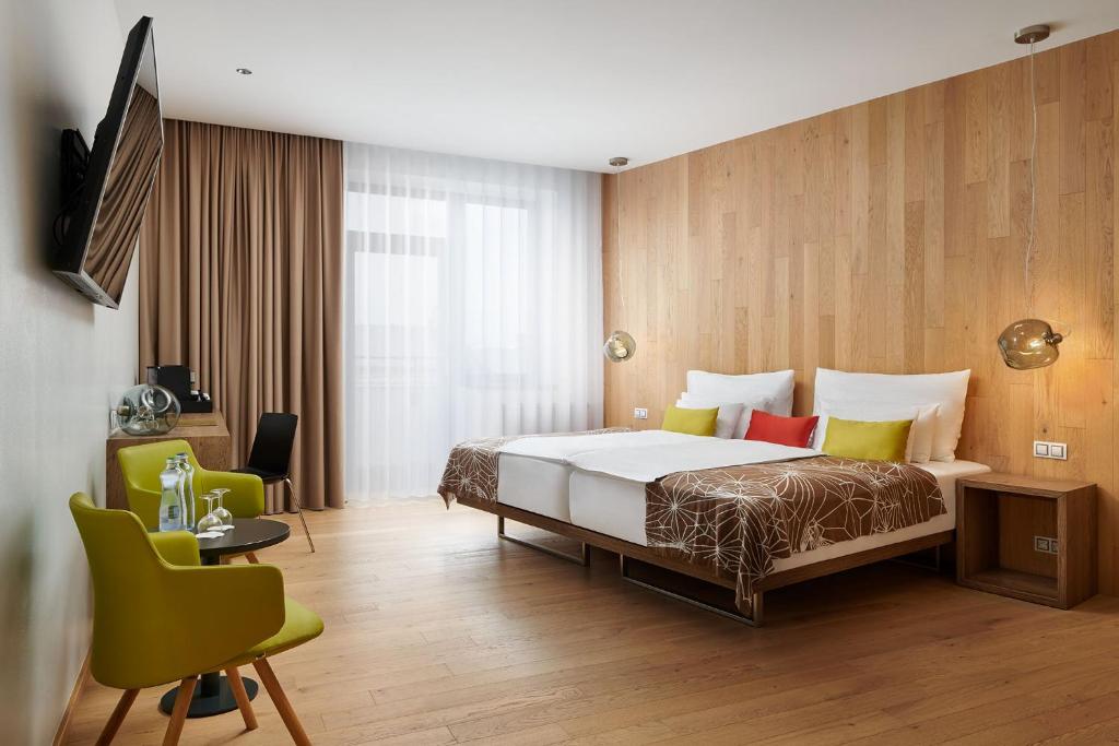 Hotel Passage في برنو: غرفة نوم بسرير وطاولة وكراسي