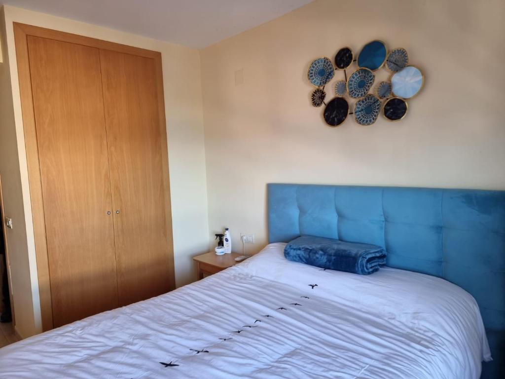 um quarto com uma cama com uma cabeceira azul em Frontal Las Terrazas 1 en Marina d`Or em Oropesa del Mar