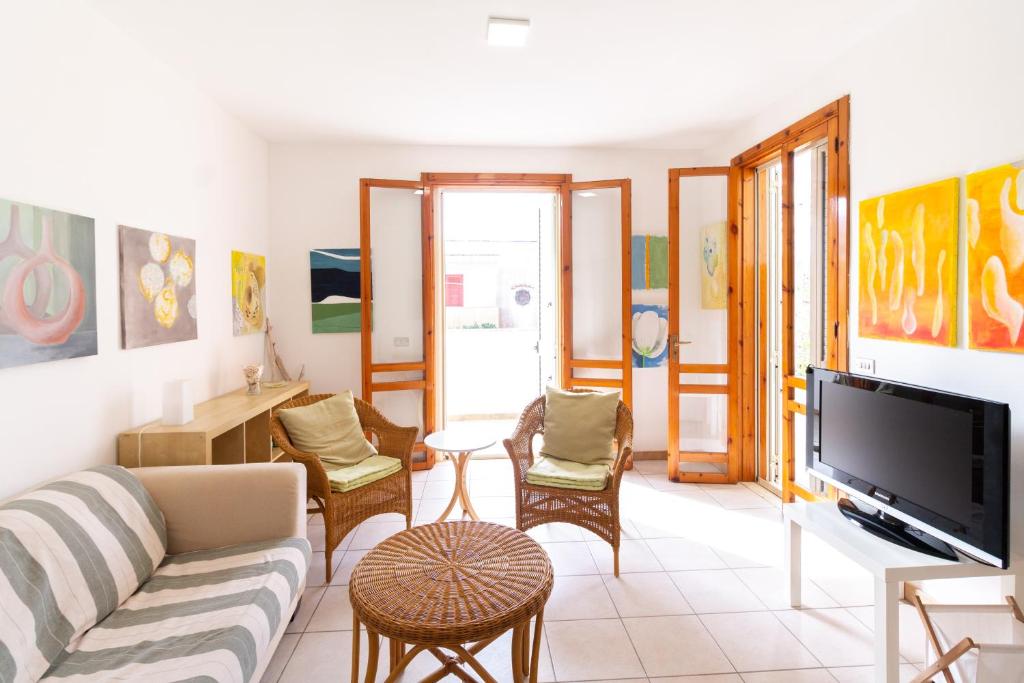 un soggiorno con un divano e una TV di Rainbow Apartment - Torre dell'orso a Torre dell'Orso