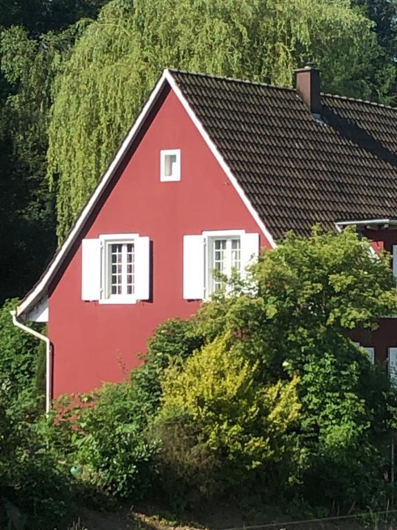 Casa roja con ventanas blancas y árboles en Villa Kunterbunt, en Härkingen