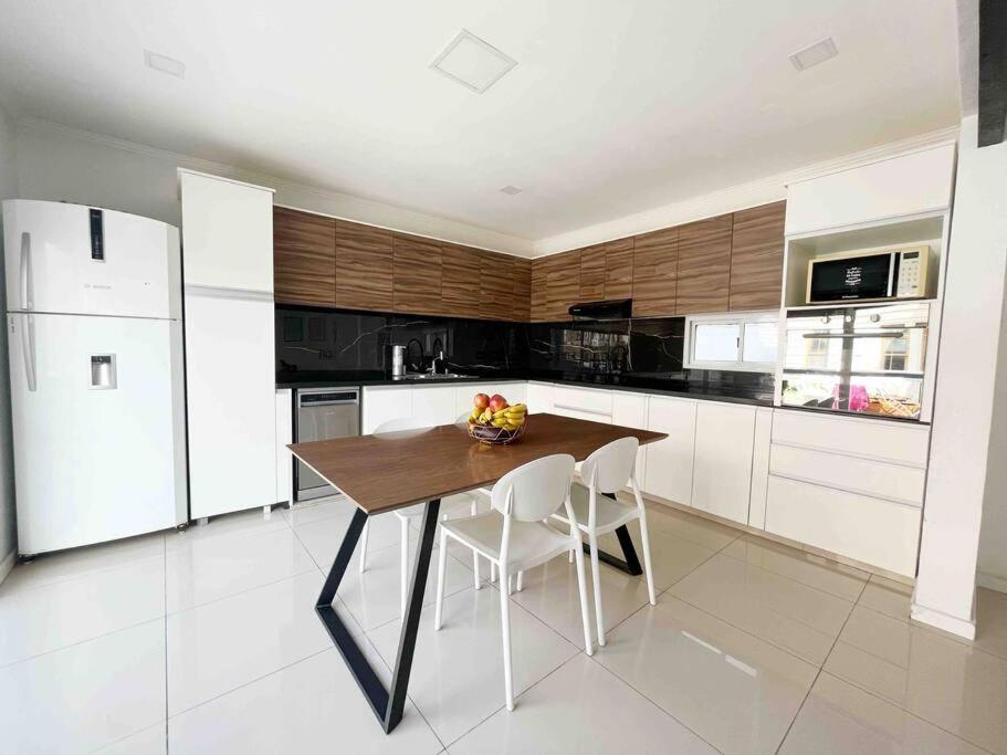 a kitchen with a wooden table and white appliances at Hermoso depto centro Rosario in Rosario