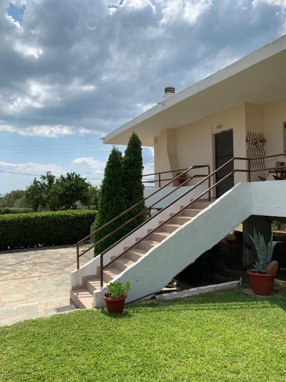 a house with a staircase in the front yard at Lefkandi Family House in Chalkida