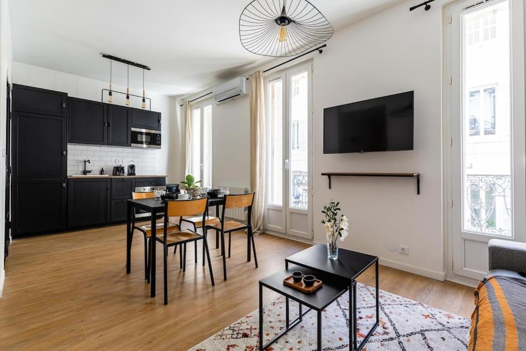 un salon avec une table et des chaises et une cuisine dans l'établissement IMHOST - Appartement luxueux climatisé -Marseille -Le Panier, à Marseille