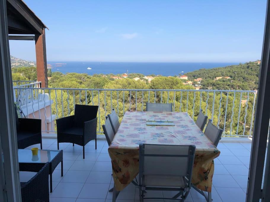 a table and chairs on a balcony with a view of the ocean at appartement pour 6 personnes cap esterel in Saint-Raphaël