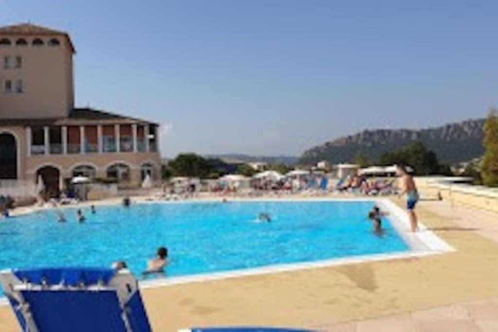 a large blue swimming pool with people in it at appartement pour 6 personnes cap esterel in Saint-Raphaël