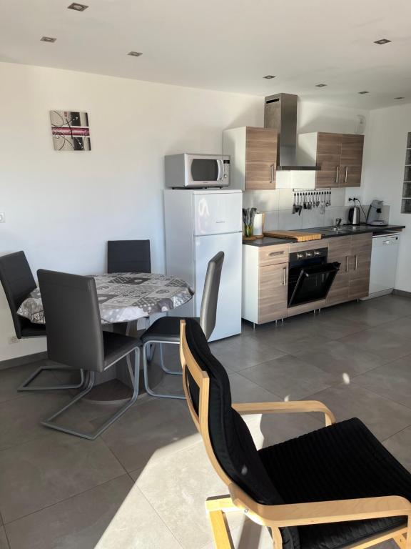 a kitchen and dining room with a table and chairs at Lac et Montagne in Chorges