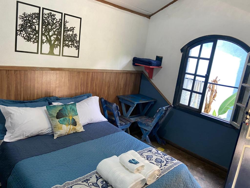 a bedroom with a bed and a window at Pousada das Brumas in Brumadinho
