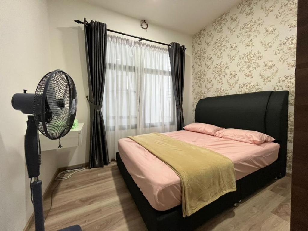 a bedroom with a bed with a fan and a window at Airbnb Homestay P Residence in Kuching