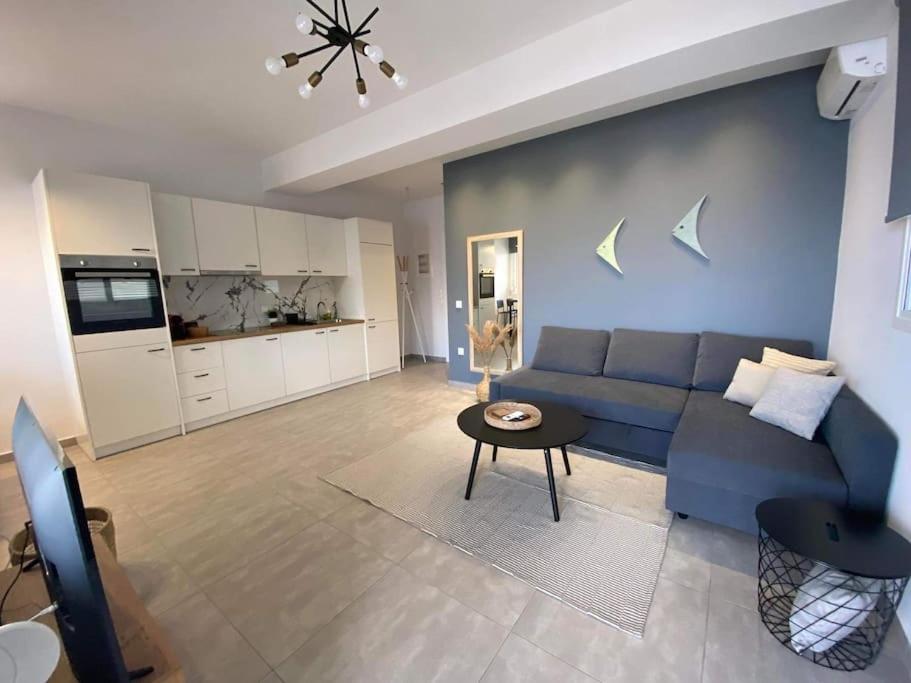 een woonkamer met een blauwe bank en een tafel bij DiFan Sea Homes A4 in Verga Kalamata