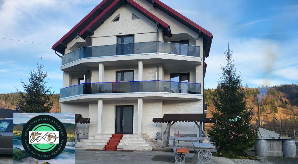 una gran casa blanca con un cartel delante en Soimii Bucovinei Residence, en Vatra Moldoviţei