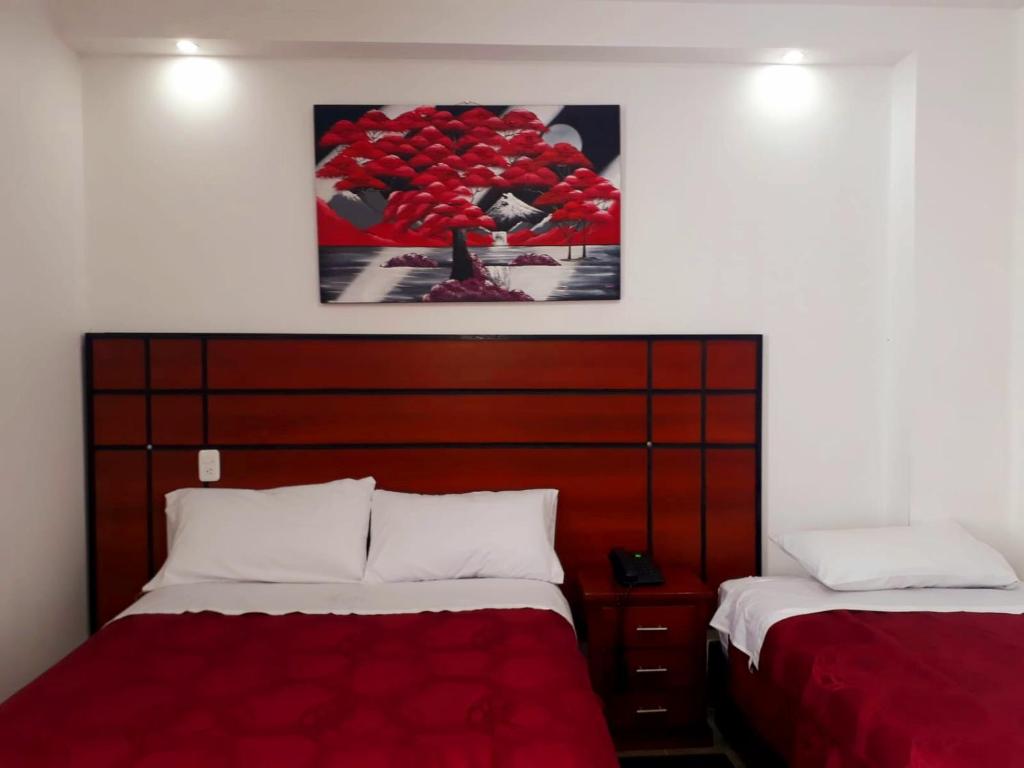 1 dormitorio con 2 camas y una foto en la pared en HOTEL DEL RIVER MONUMENTO en Sangolquí
