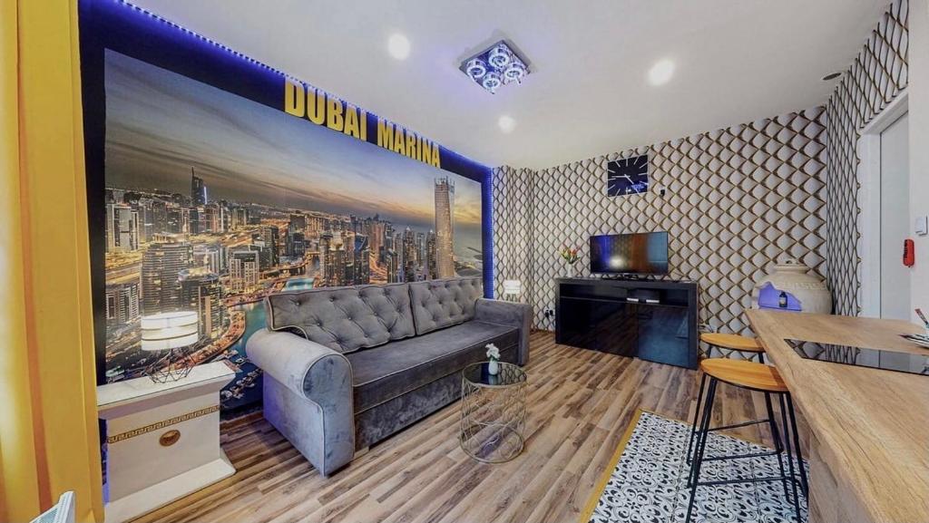 a living room with a couch and a large wall mural at DUBAI MARINA DE LUX in Bytom