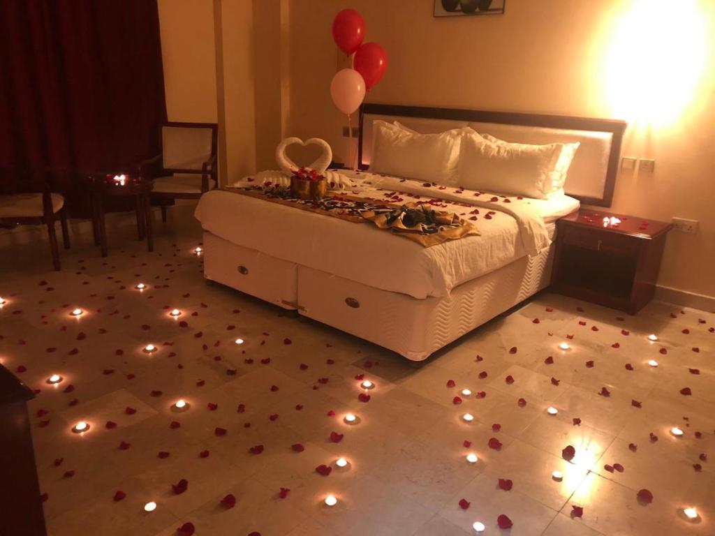 1 dormitorio con 1 cama con luces y globos en el suelo en Farah Hotel Apartment, en Mascate