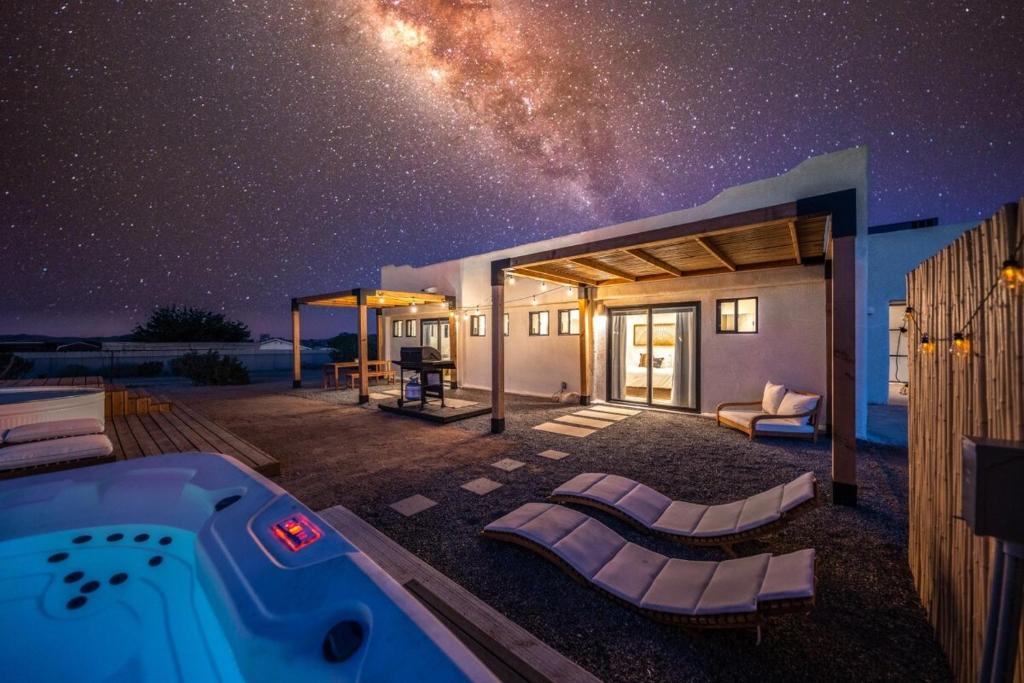 a starry sky over a house with a hot tub at Hot Tub, Yoga Room, Cowboy Pool, Firepit in Joshua Tree