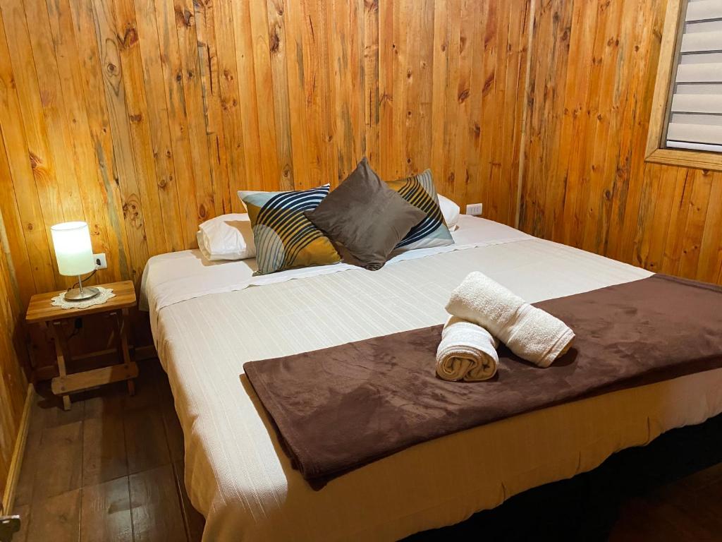 een slaapkamer met een bed met twee handdoeken erop bij Cabañas Puerto Aysen in Puerto Aisén