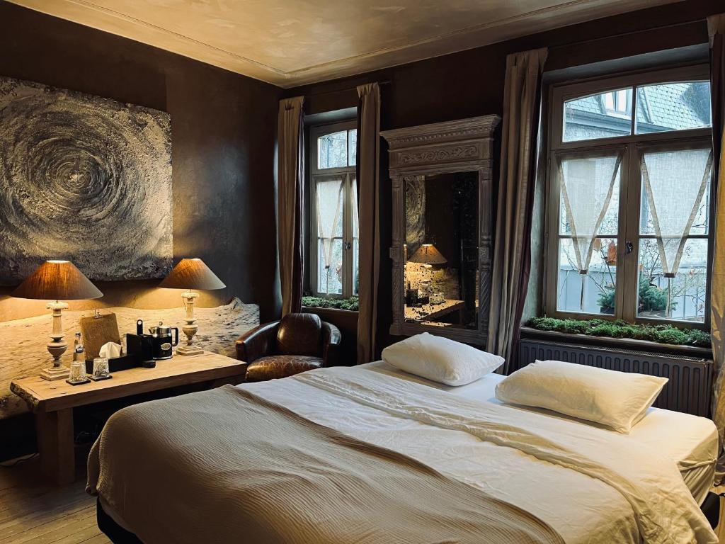- une chambre avec un lit, un bureau et des fenêtres dans l'établissement Édouard Garden Café Guest Room, à Durbuy