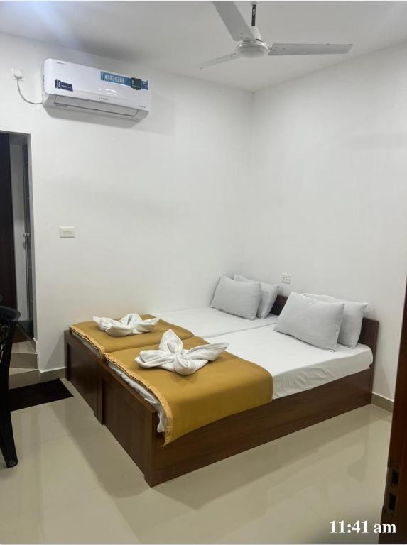 a bedroom with a large bed with a fan on the wall at LEMER SUITES in Cochin
