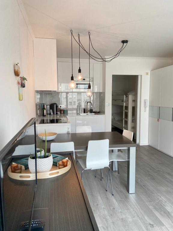 a kitchen and dining room with a table and chairs at Studio Delfien in Oostduinkerke