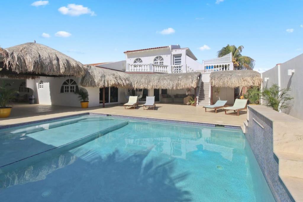 a swimming pool in front of a house at Beach Walk Residences in Palm-Eagle Beach