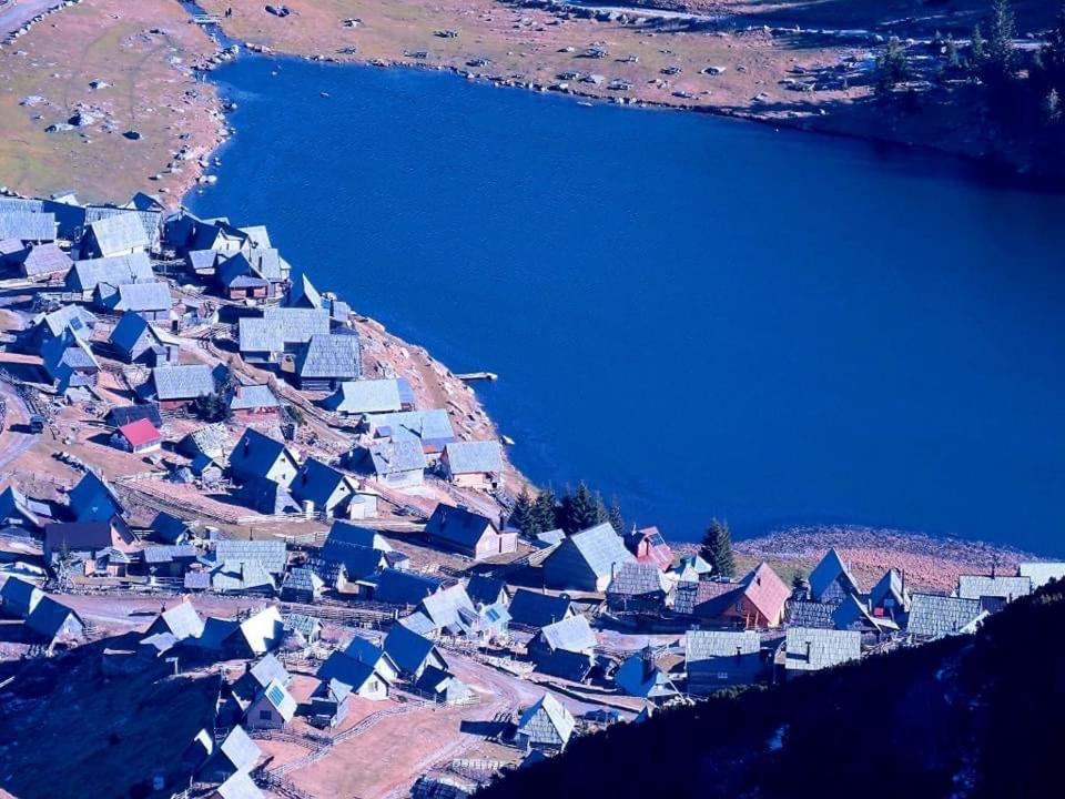 an aerial view of a village next to a body of water at Zlatna koliba Namir Zuka in Fojnica