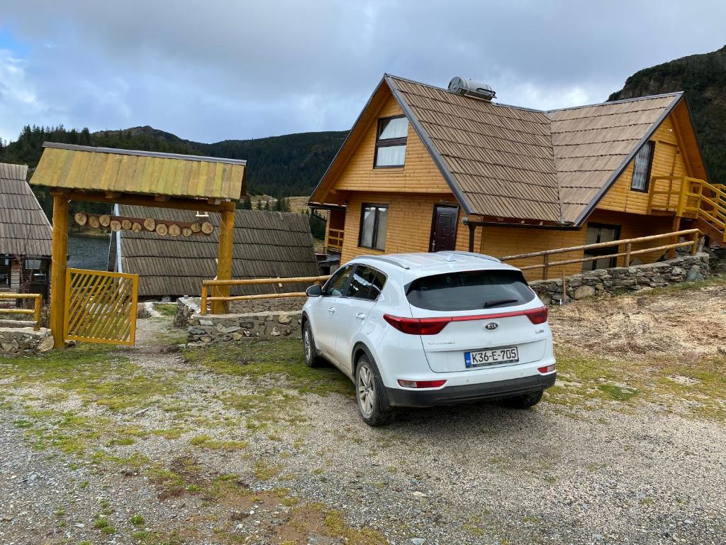 a white car parked in front of a house at Zlatna koliba Namir Zuka in Fojnica