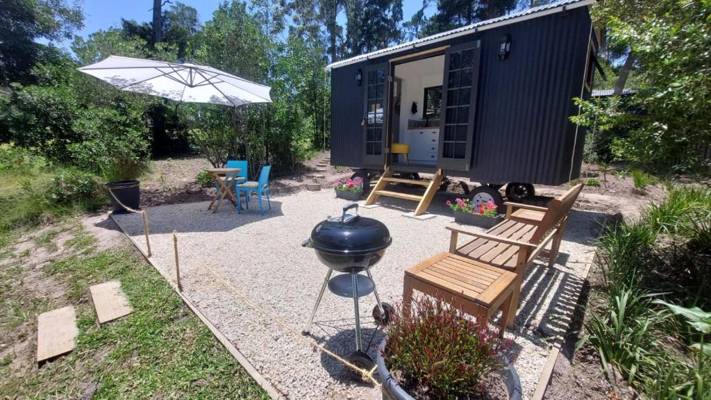 a black tiny house with a bbq and a grill at Luxury Shepherds Hut Retreat in Plettenberg Bay