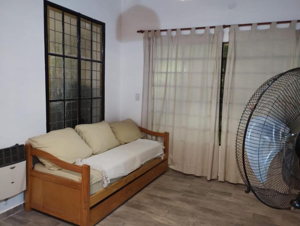 Habitación con cama, ventilador y ventana. en Casa con pileta en Funes en Funes