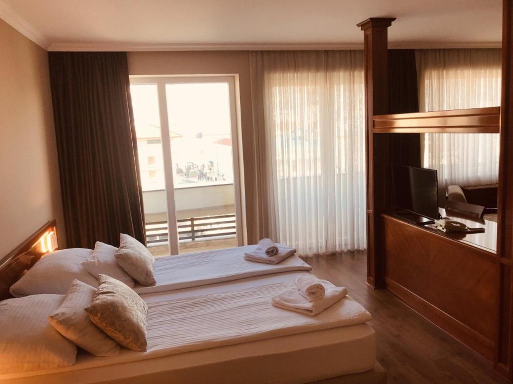 فندق بريستول في موستار: غرفة فندق عليها سرير وفوط