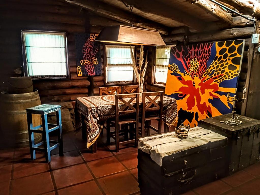 a dining room with a table and a stove in a cabin at Malo Watson Hostel in Tandil