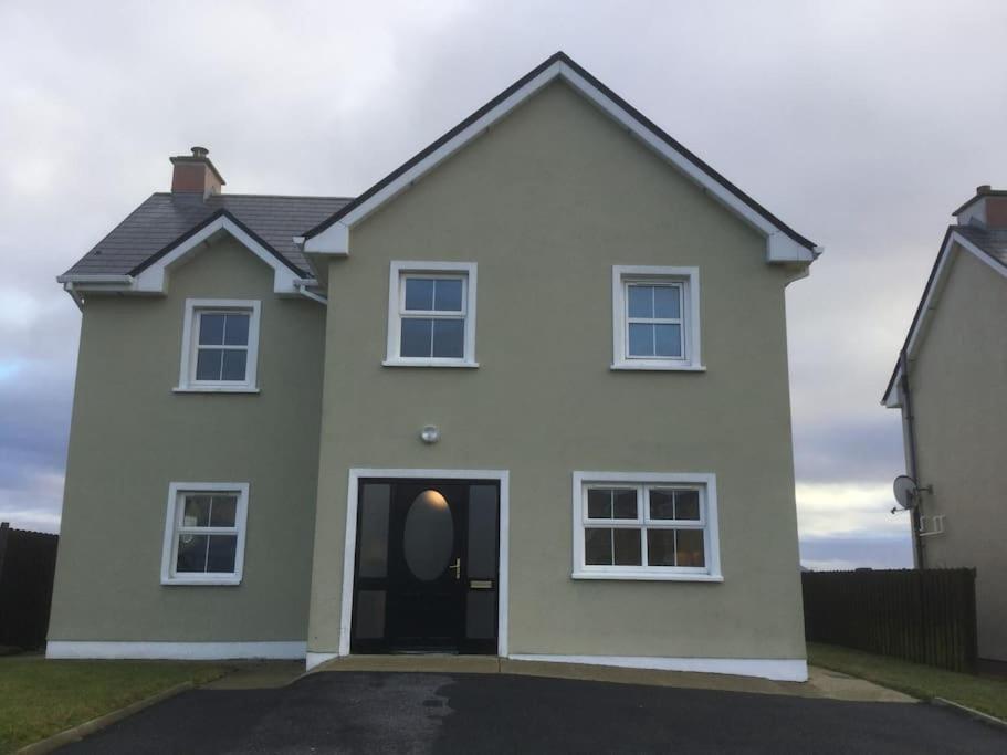 una casa blanca con una puerta negra en Home On The Edge Of Ireland!, en Belmullet