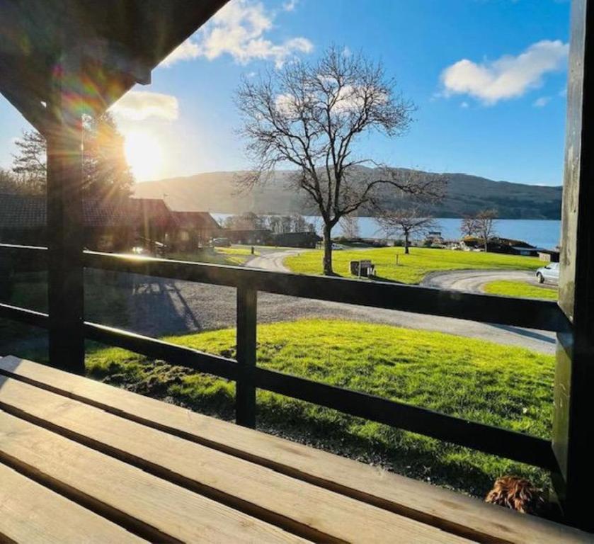 una vista desde el porche de una casa con un banco en Bell Rock Holiday Lodge en Killin