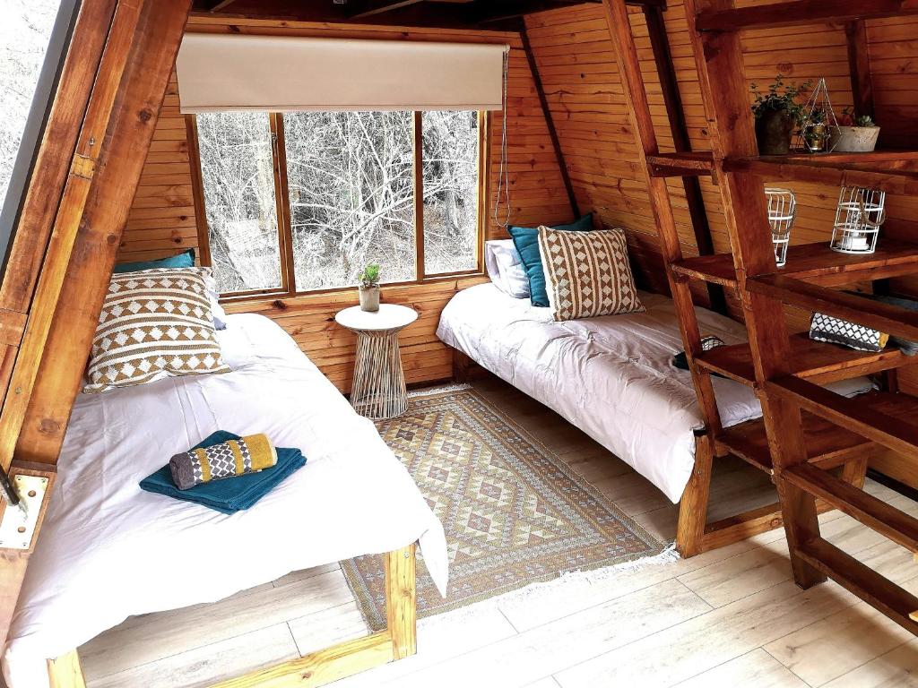 a room with two beds in a log cabin at Gaia A-frame cabin in Swellendam