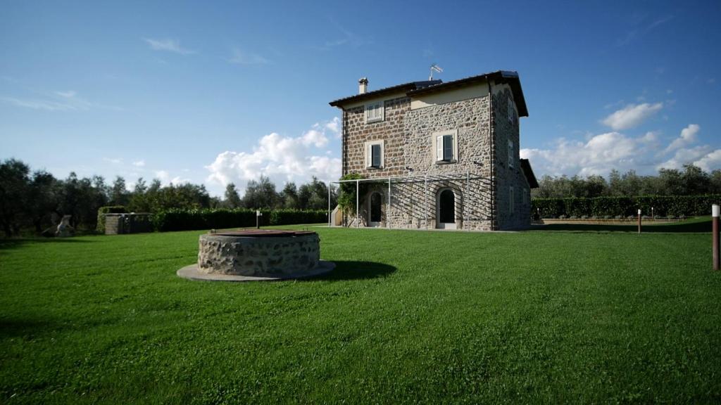 a large stone building in a field of grass at Agriturismo I Due Casali in Vetralla