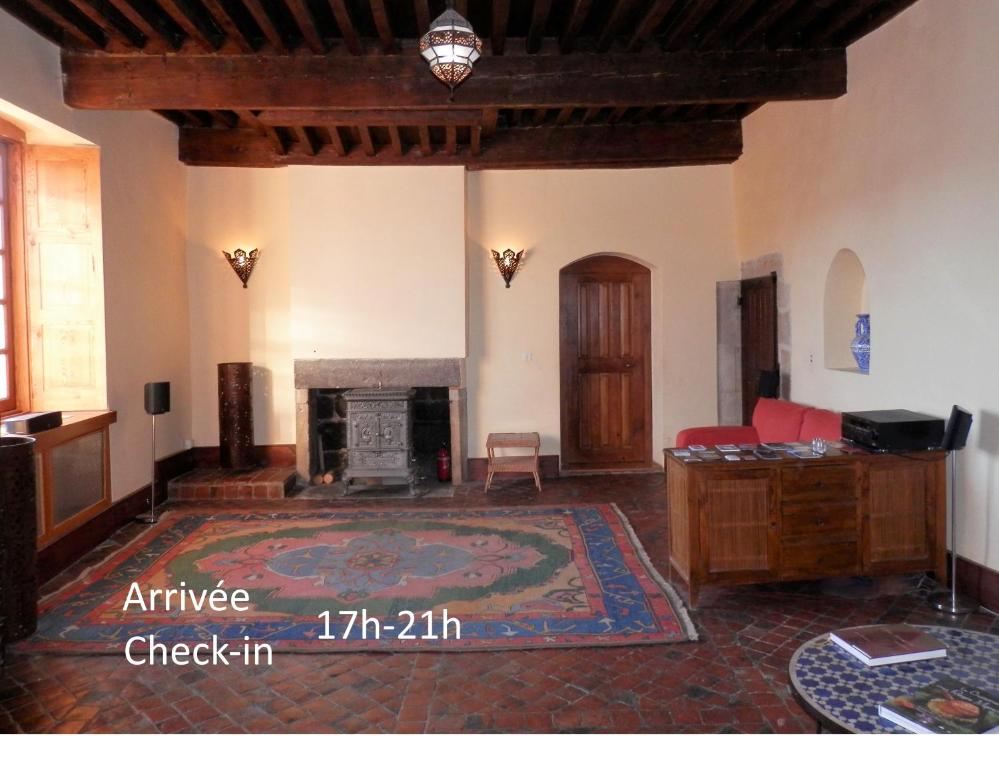 sala de estar con chimenea y alfombra en Chambres d'hôtes La Prévôté - Ancien couvent contre la Cathédrale, en Le Puy en Velay