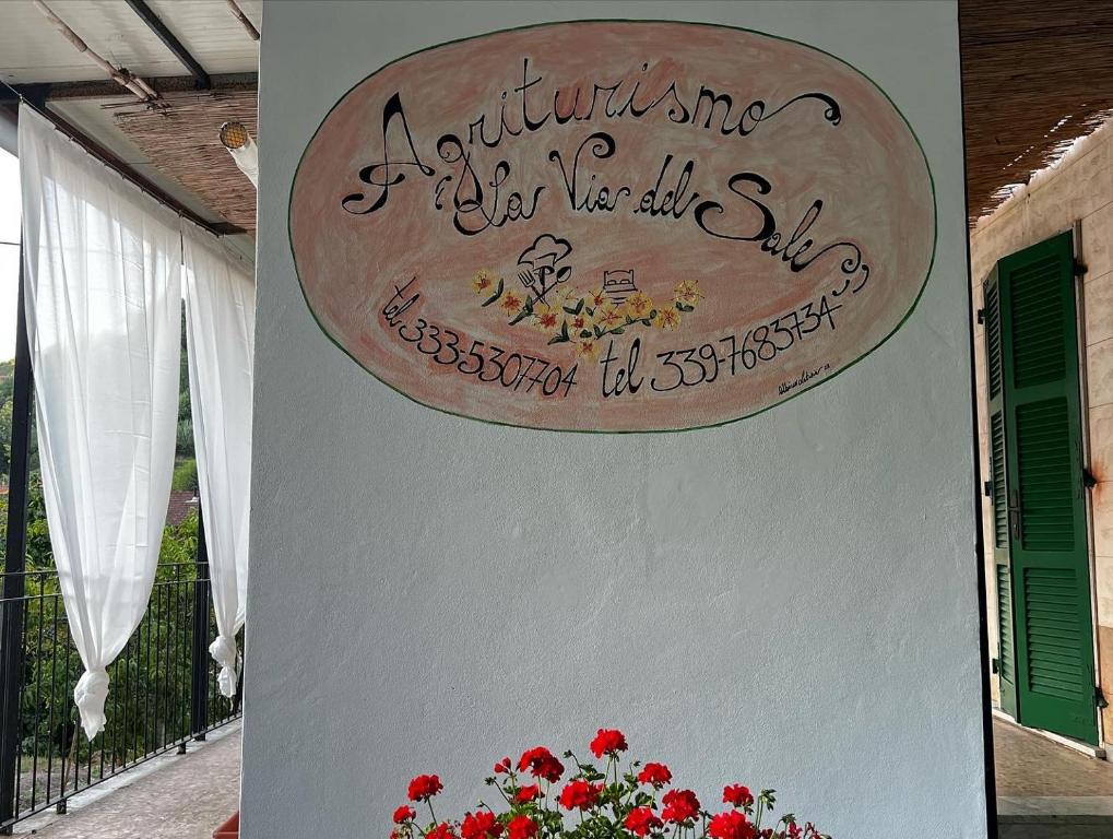 znak na boku budynku z czerwonymi kwiatami w obiekcie agriturismo La via del sale2 w mieście Pignone