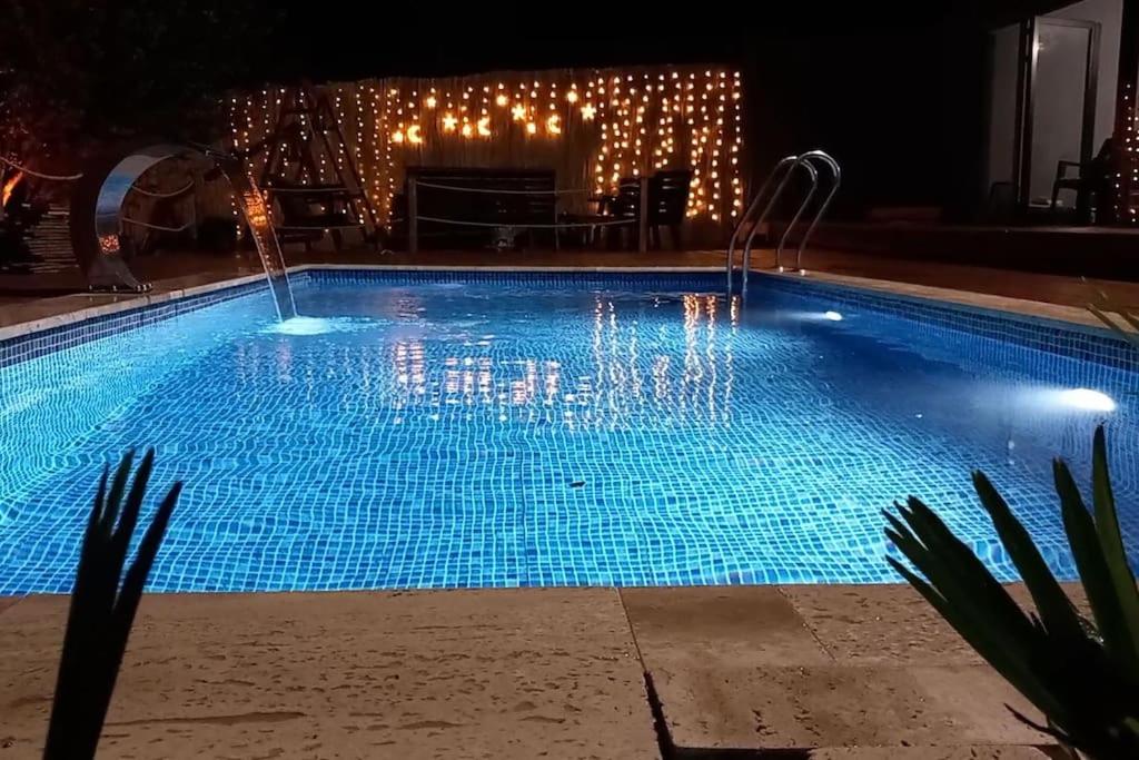 ein Schwimmbad in der Nacht mit Weihnachtsbeleuchtung in der Unterkunft Kozalak Villa in Sapanca