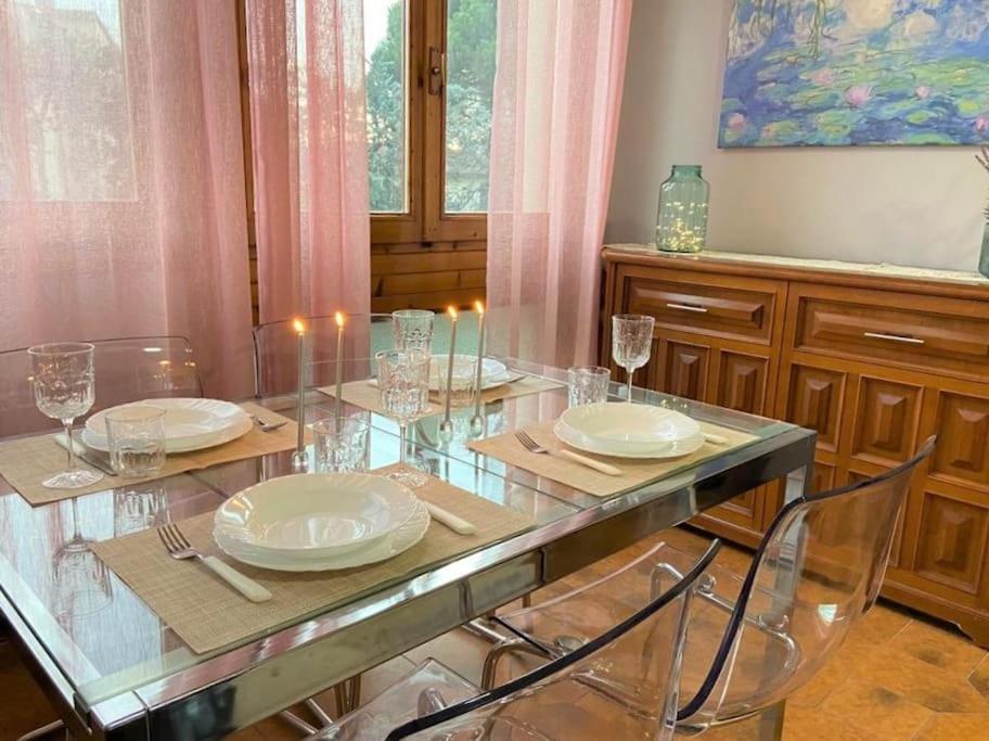 a dining room table with plates and glasses on it at Camilla Florence Apartment in Florence