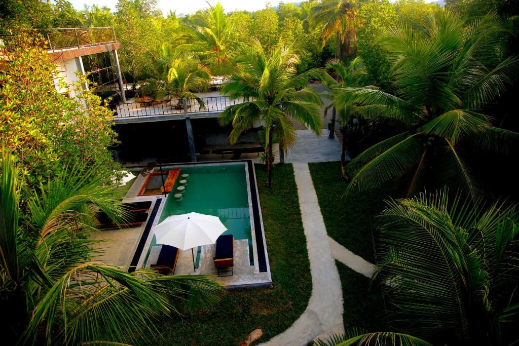 uma vista aérea de um resort com uma piscina e um guarda-sol em VODA Hotel & Spa em Galle