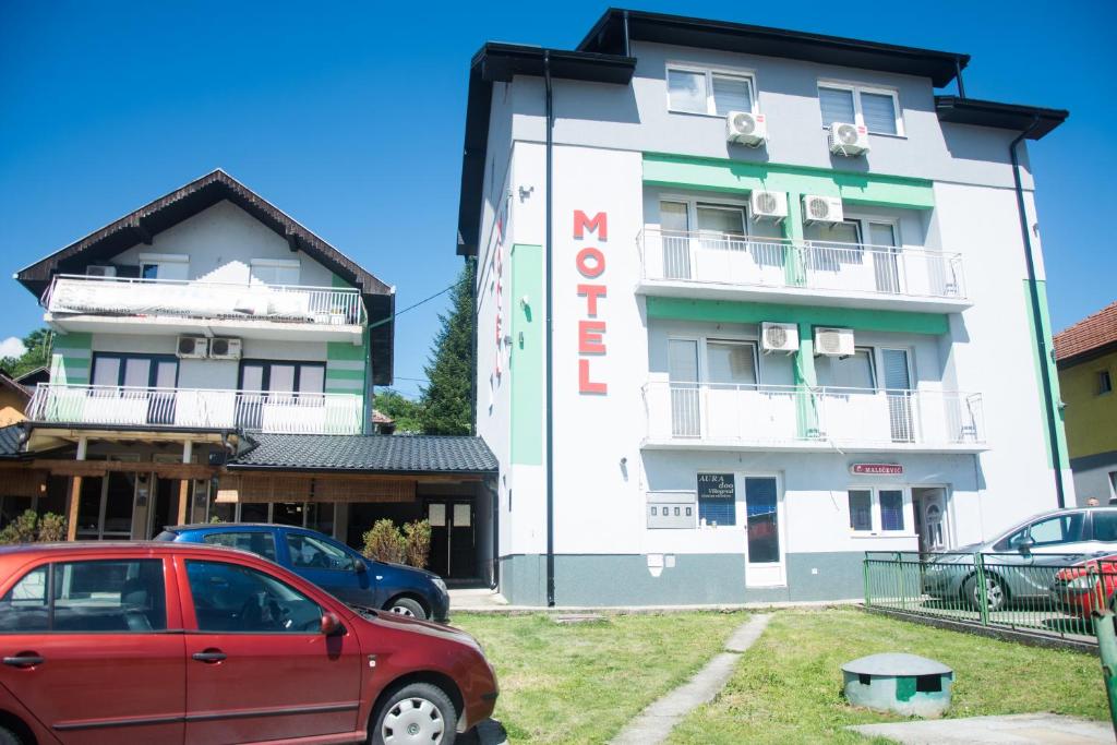 ein Gebäude mit einem roten Auto, das davor geparkt ist in der Unterkunft Motel Aura in Višegrad
