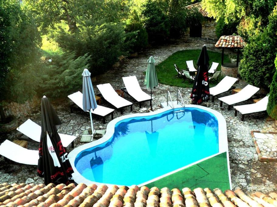 a swimming pool with chairs and umbrellas next to at VILLA GALATA in Varna City