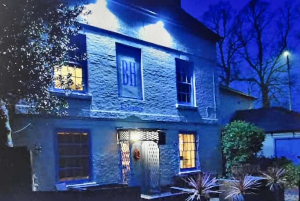 a blue brick house with a sign on it at night at Blenheim House Hotel in Etwall