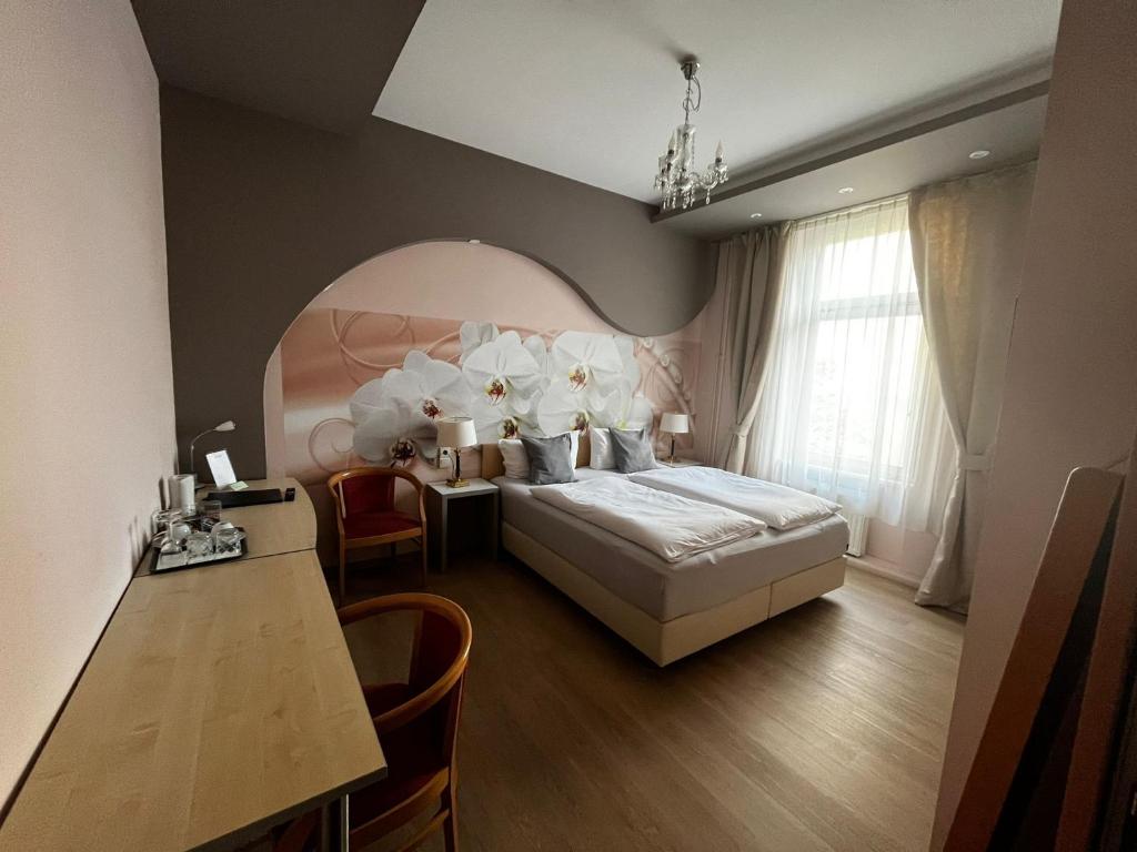 1 dormitorio con cama, escritorio y mesa en Pension Oase, en Berlín